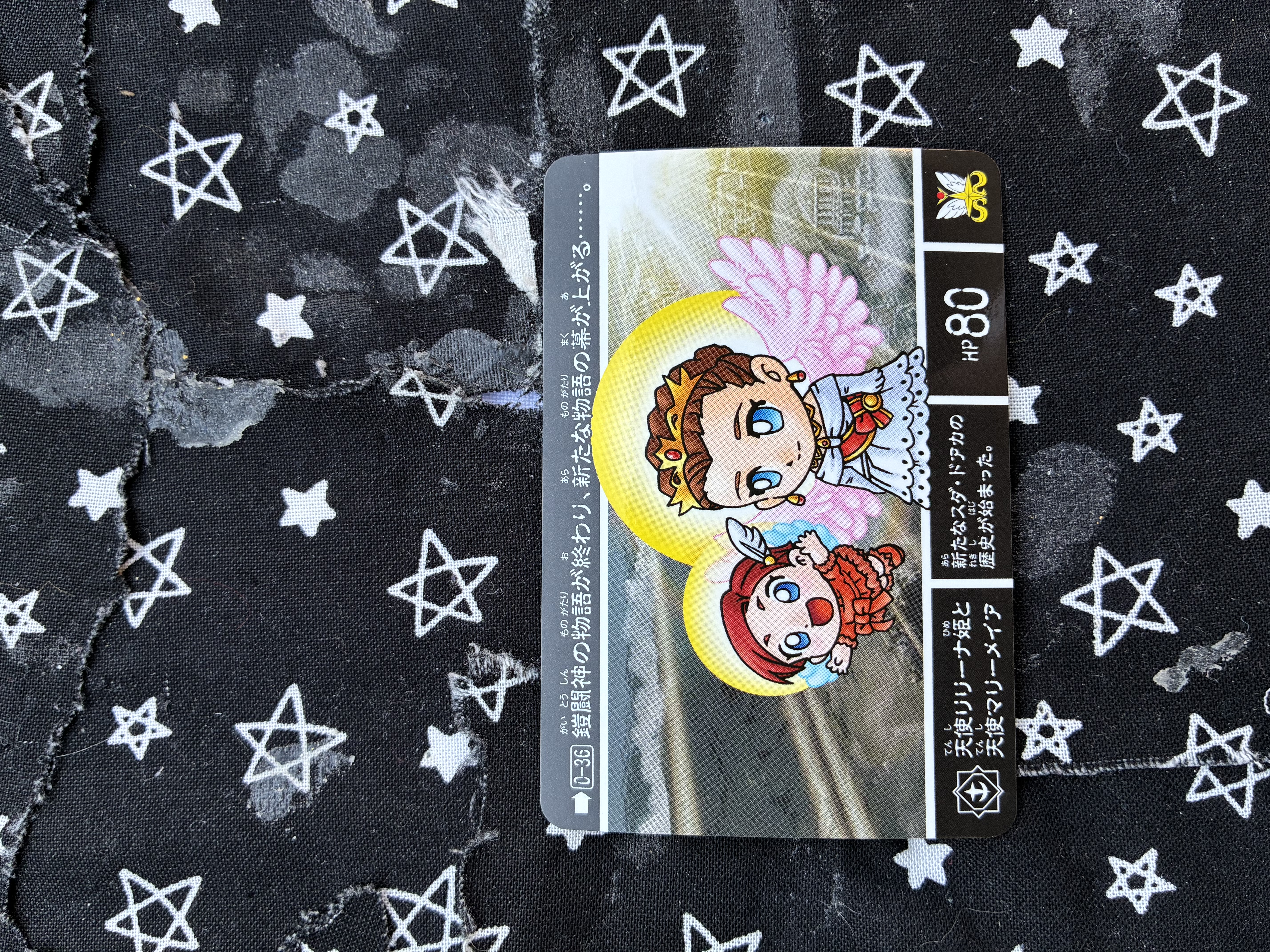 A Bandai SD Gundam Gaiden Carddass collectible trading card featuring Relena in her queen of the world outfit with angel wing and Mariemaia in a red dress with a bow and angel wings.